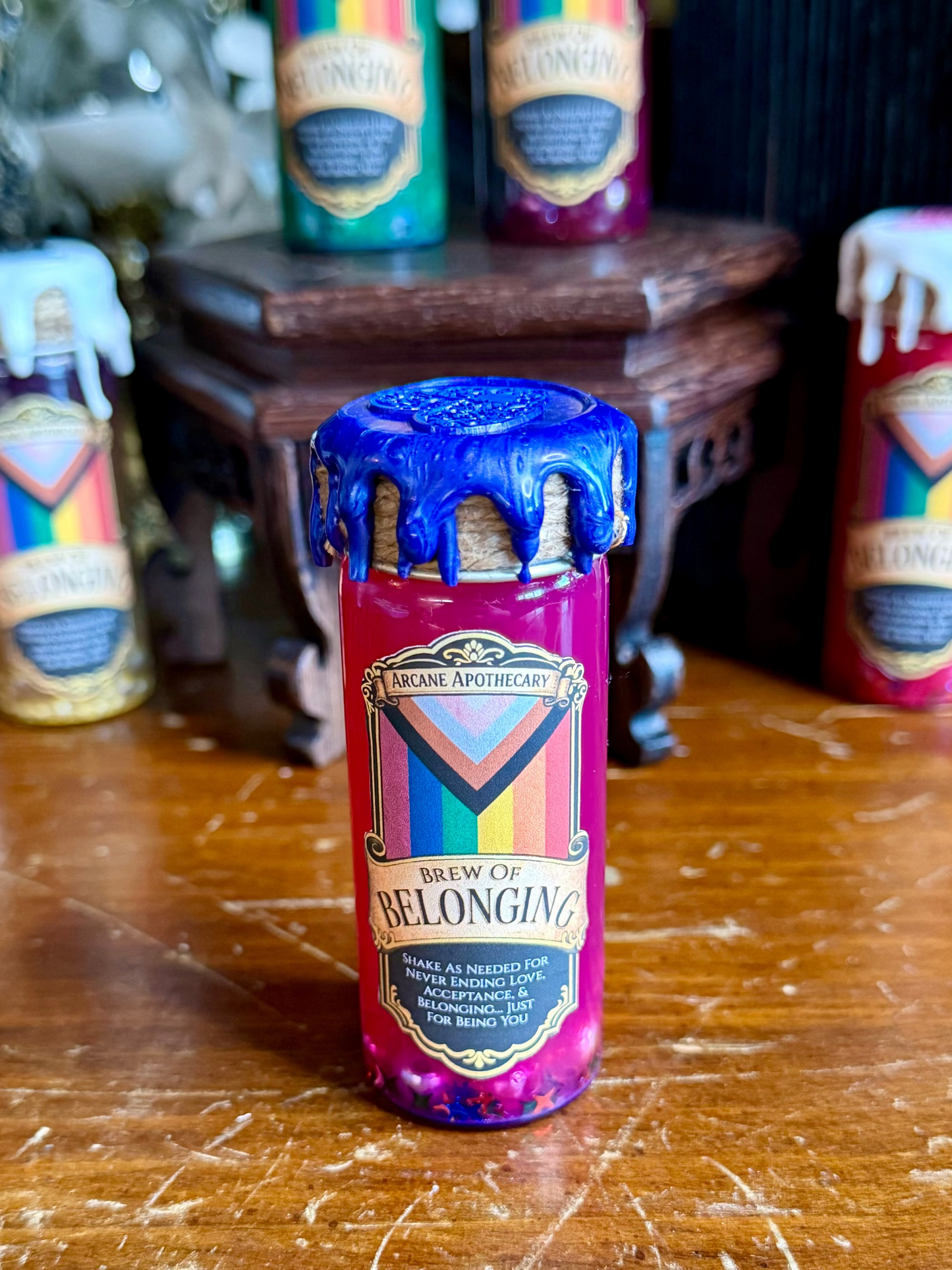 Bottle of 'Brew of Belonging' with colorful label on a wooden surface